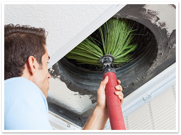 Technician performing air duct cleaning.